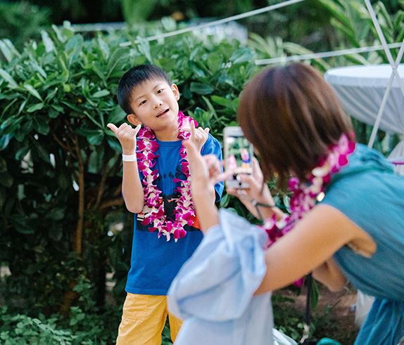 A child poses for a photograph wearing a lei during a 'Beach Bash' event in Honolulu Hawaii.