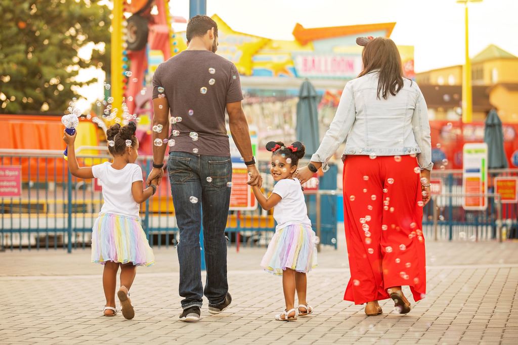 A family of four walking hand-in-hand through a theme park with the copy '8-night family getaway to Orlando'.